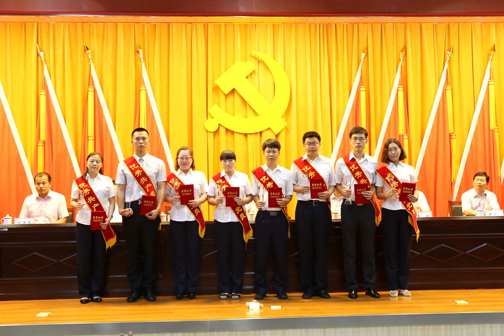 受表彰的优秀共产党员上台领取奖杯和证书